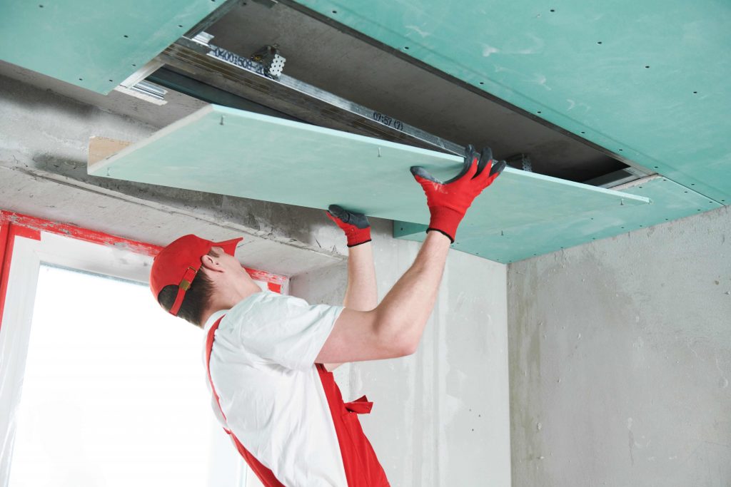 Plasterer installing a gyprock board on a false ceiling