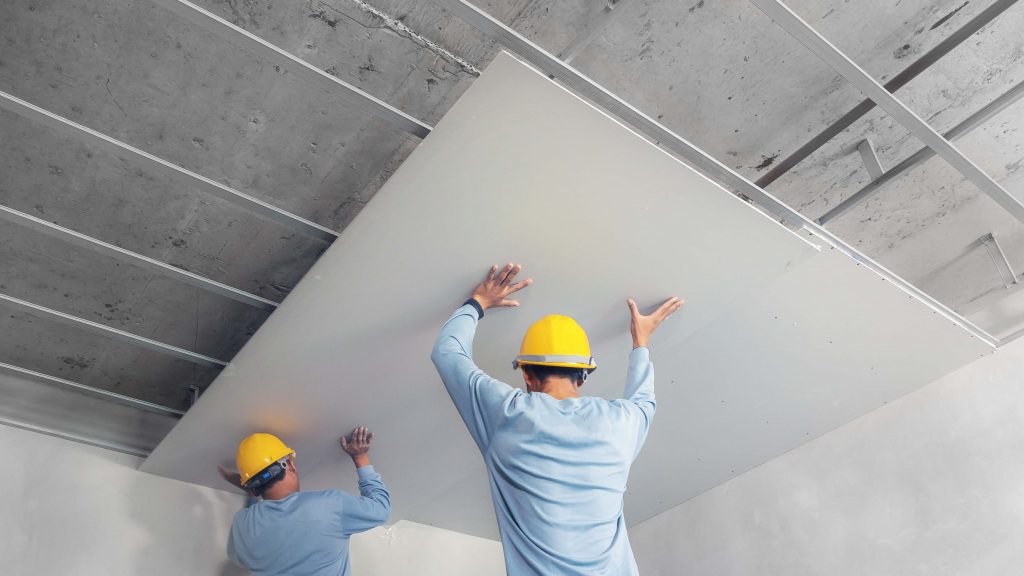 Gyprocker mounting a plasterboard sheet on metal frames ceiling