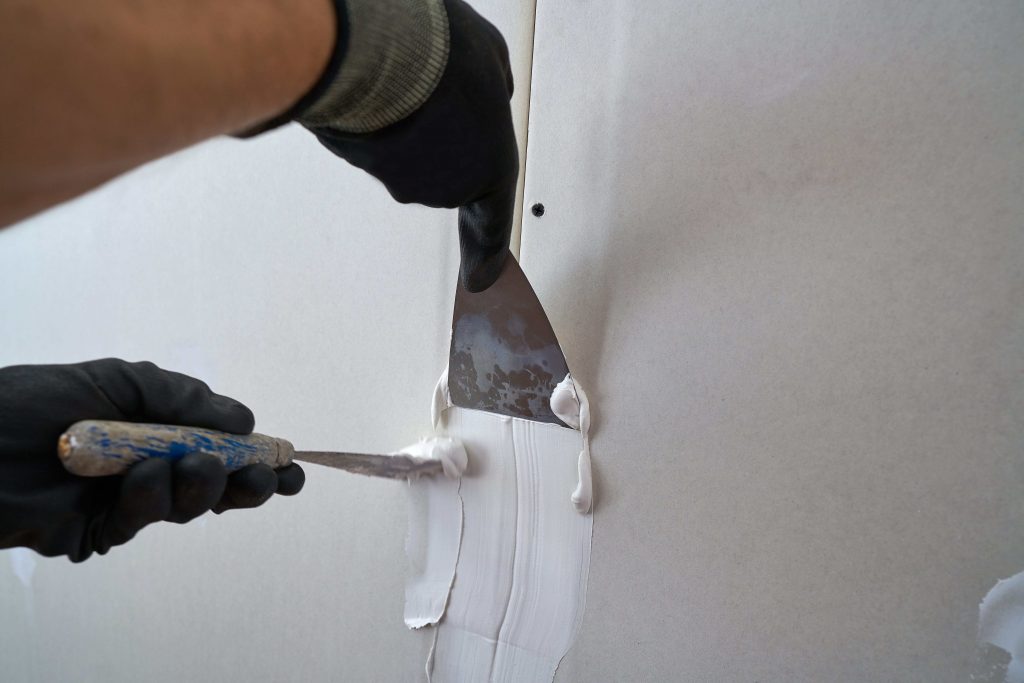 Contractor laying plastering on a gyprock wall